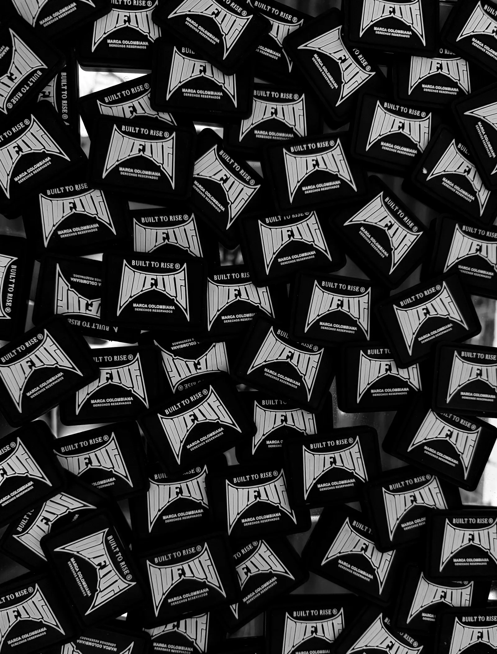 Etiquetas negras OUFIVE con el logotipo y la frase Built to Rise.